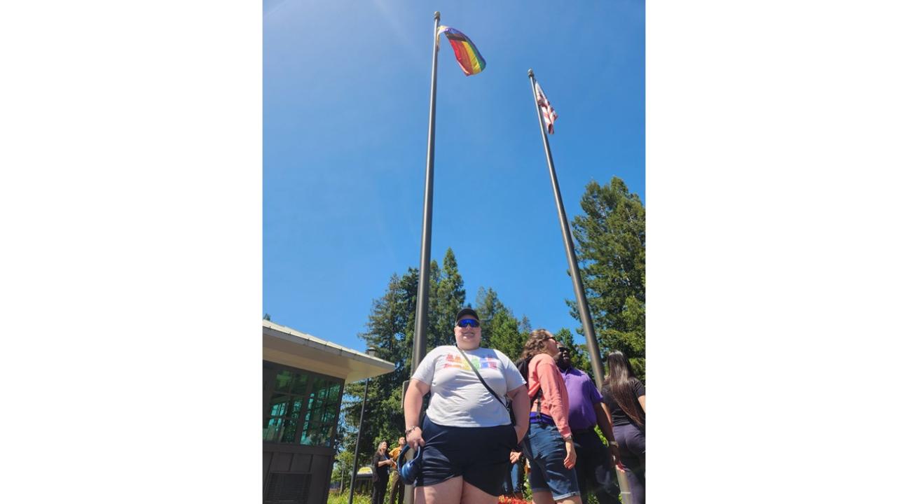 Xander Sterling at the campus flag pole after raising the Pride Flag