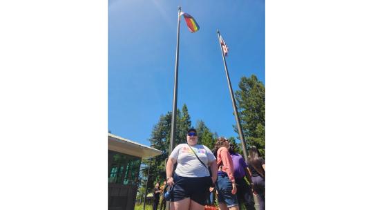 Xander Sterling at the campus flag pole after raising the Pride Flag